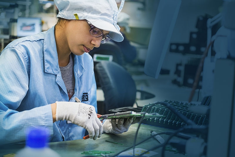 Technician working on a circuit panel during industrial electric motor and VFD equipment assembly.