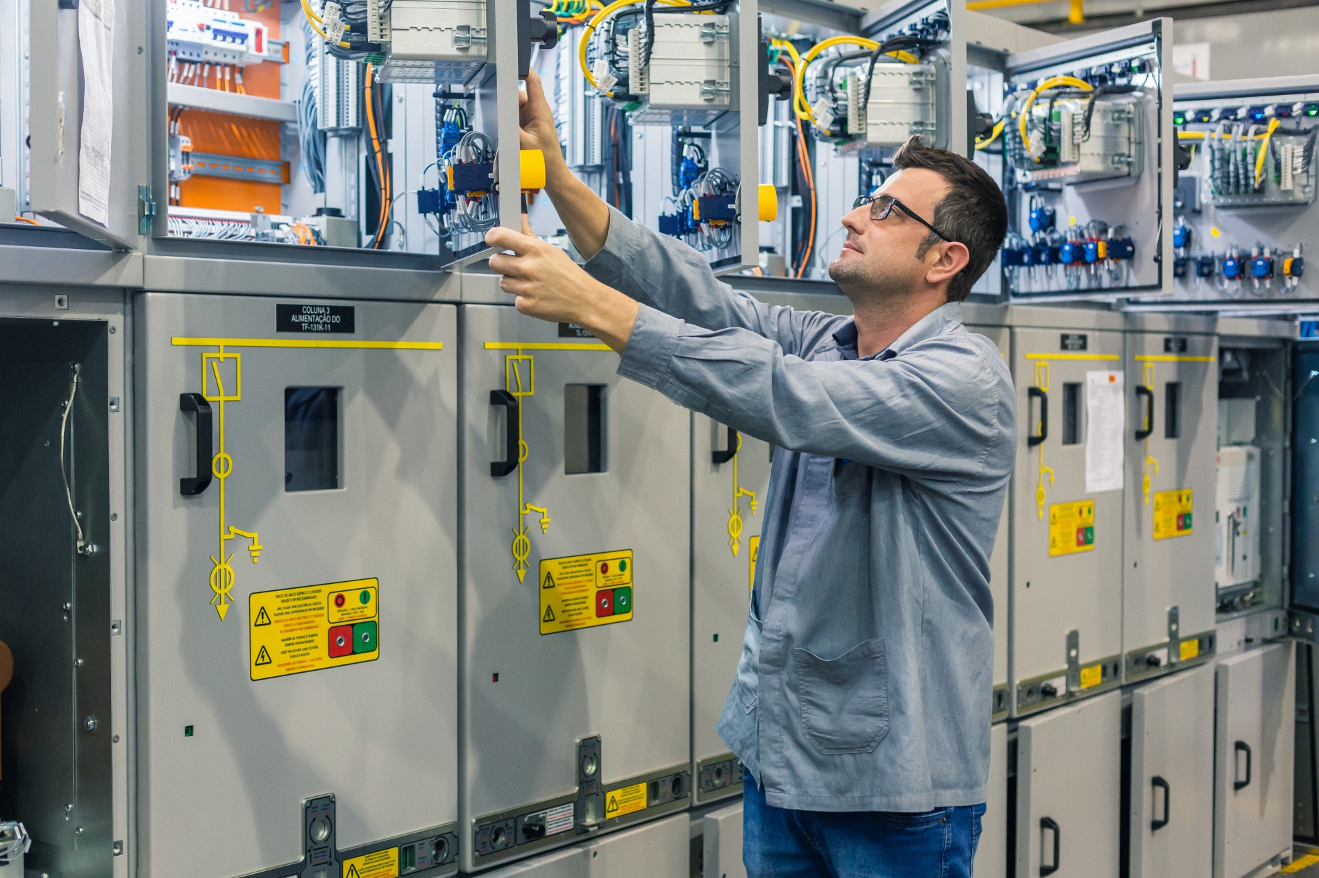 A technician inspecting an industrial electrical panel, ensuring proper operation and optimal performance in an industrial setting.