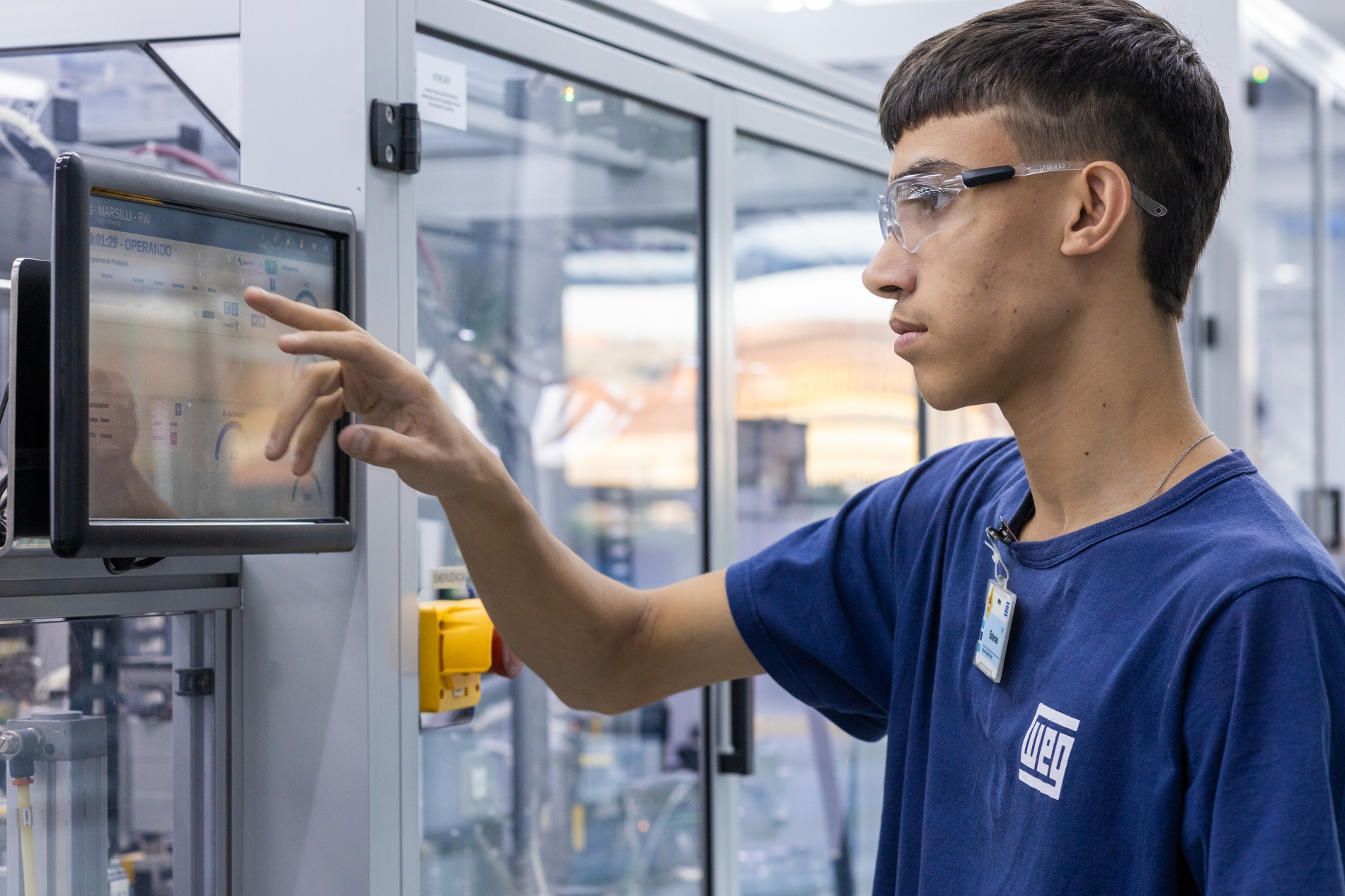 Engineer using a digital touchscreen interface to monitor and optimize motor performance in a smart industrial automation setup.