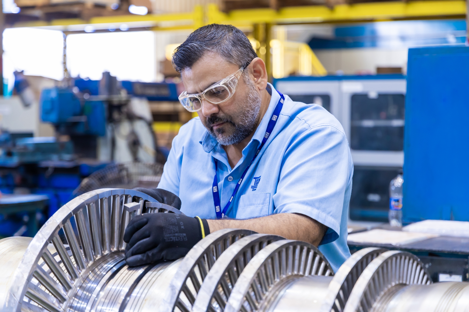 Technician inspecting an advanced industrial motor component, ensuring precision and efficiency in manufacturing operations.