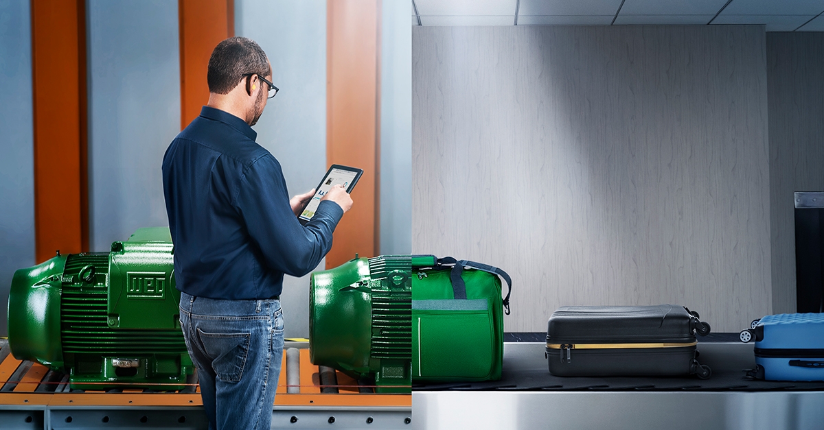 Engineer monitoring electric motors on an automated baggage conveyor system using a tablet.