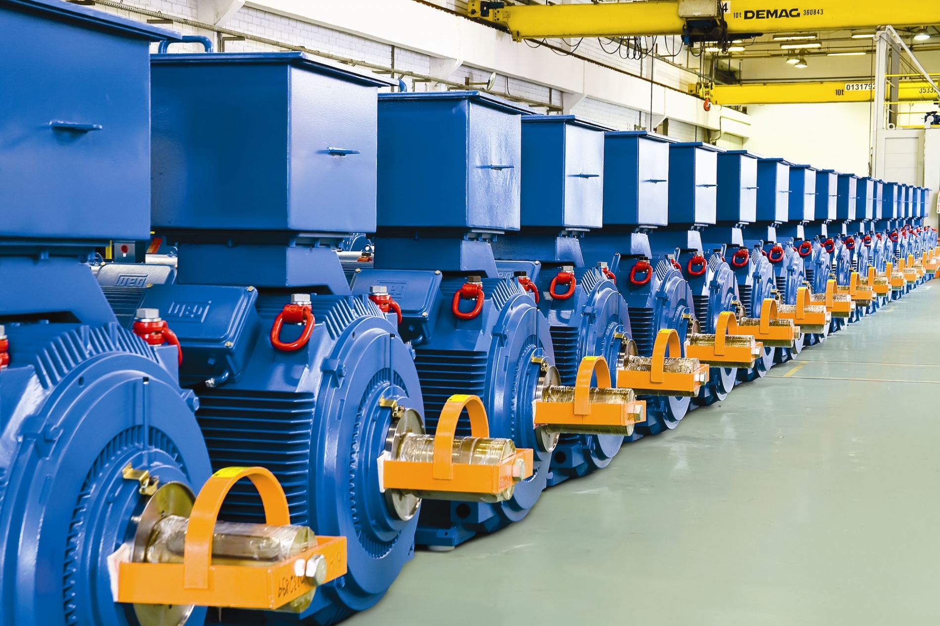 Row of large blue electric motors in a facility.
