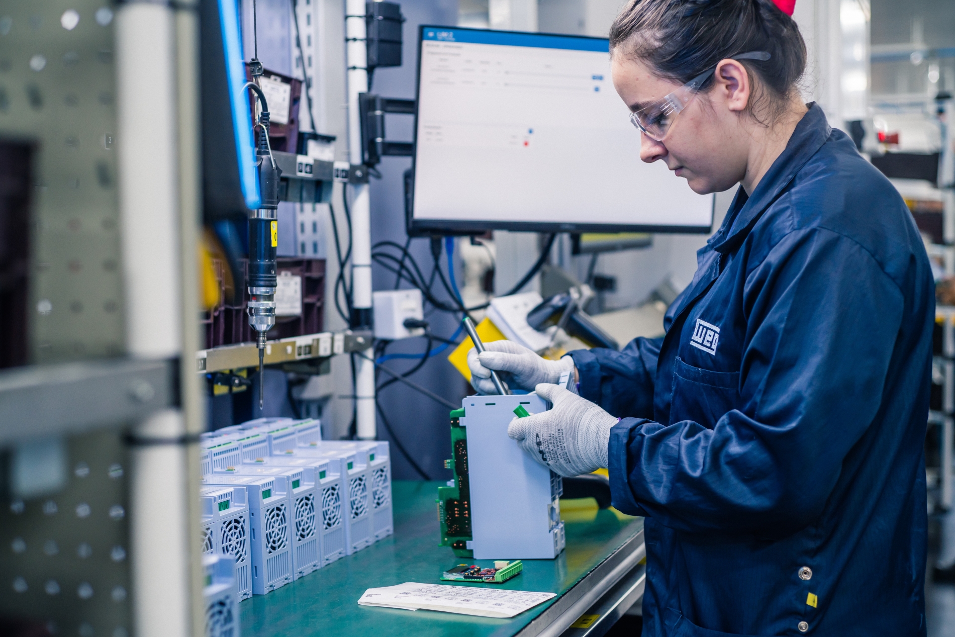 Technician assembling variable frequency drive components in an industrial facility.