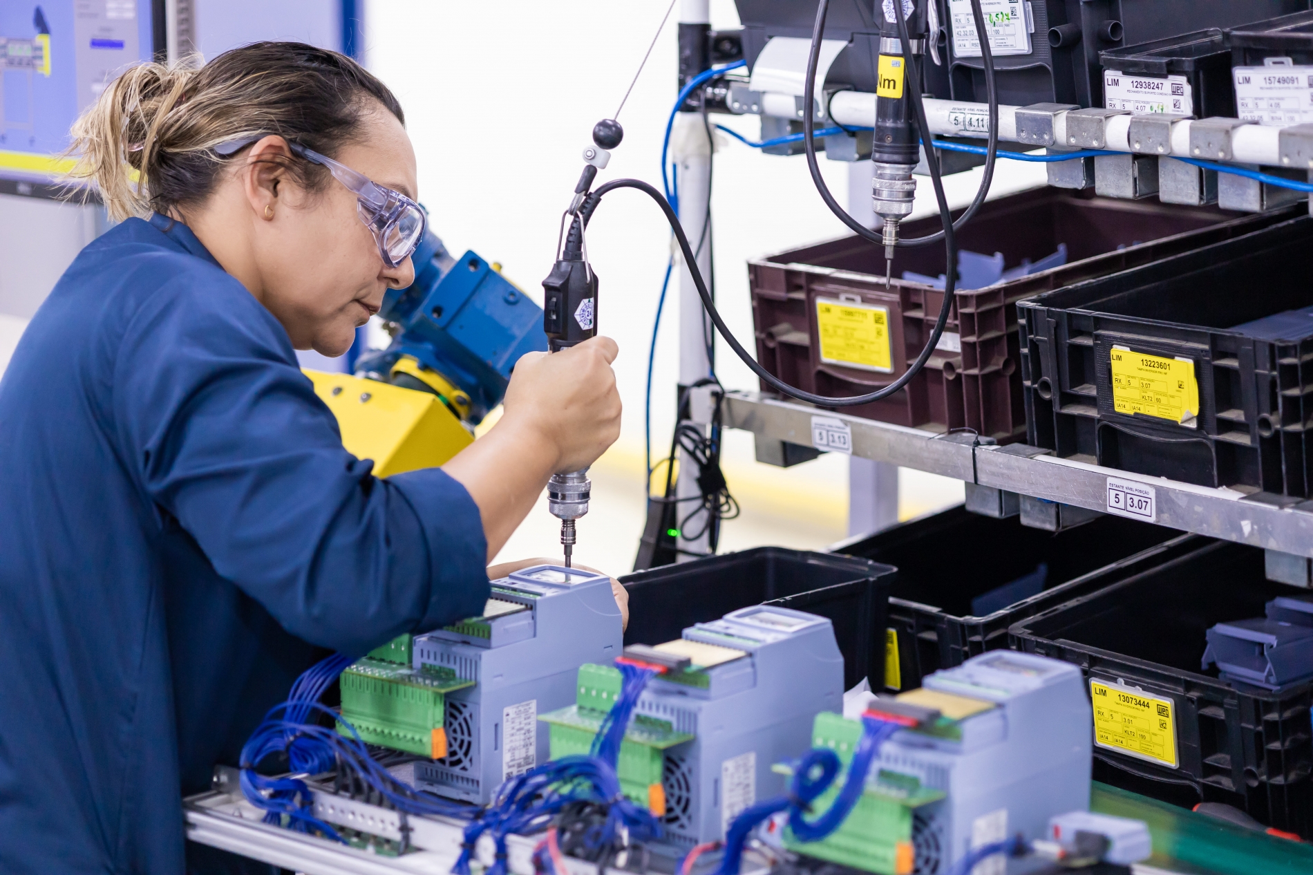 Engineer assembling and testing VFD compatibility with hand tools on a manufacturing workbench.