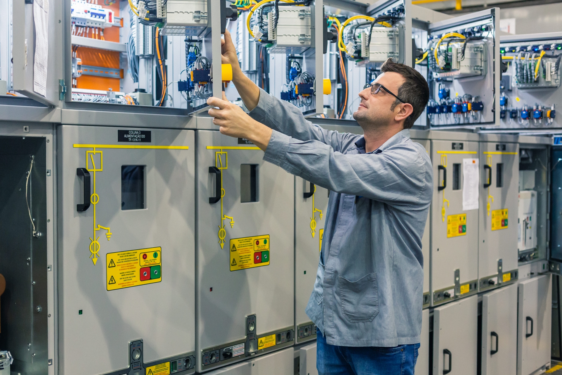 Technician connecting wiring through an industrial control panel to ensure VFD compatibility.