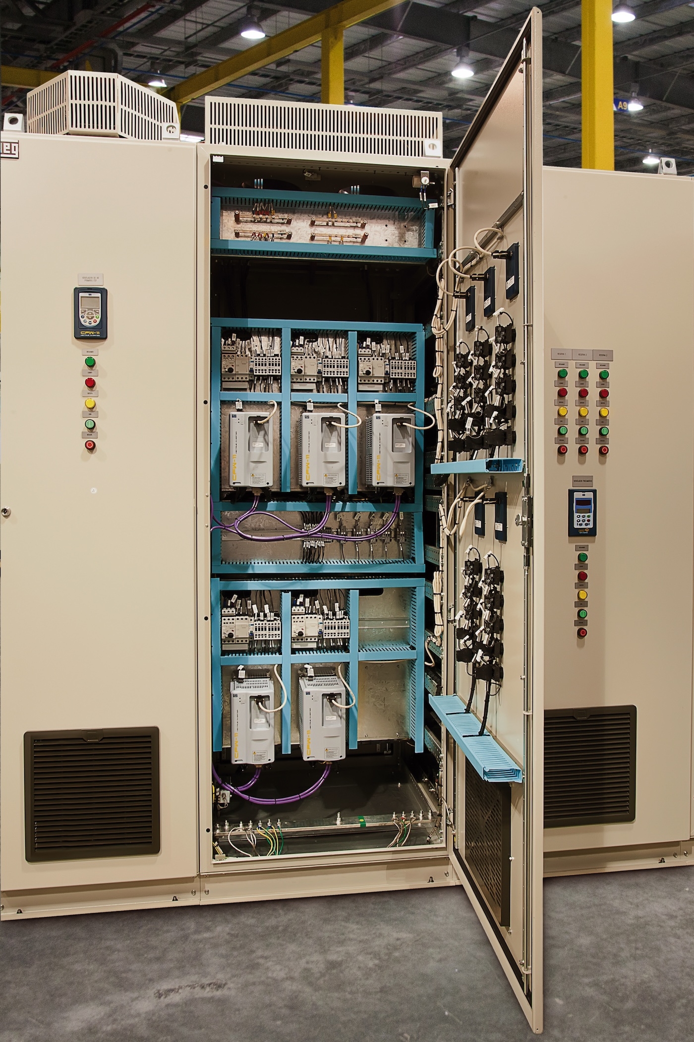 Interior of an open industrial control cabinet for VFD compatibility with electric motors.