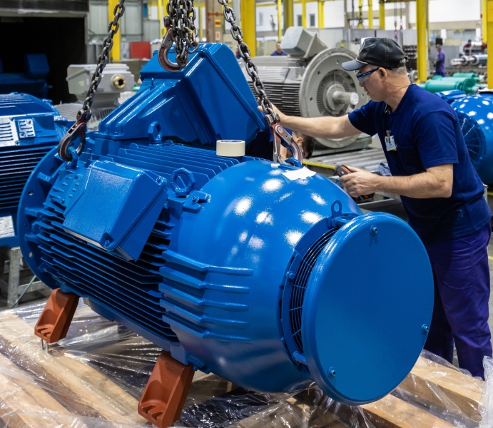 Technician inspecting a high-efficiency electric motor before installation for industrial motor service.