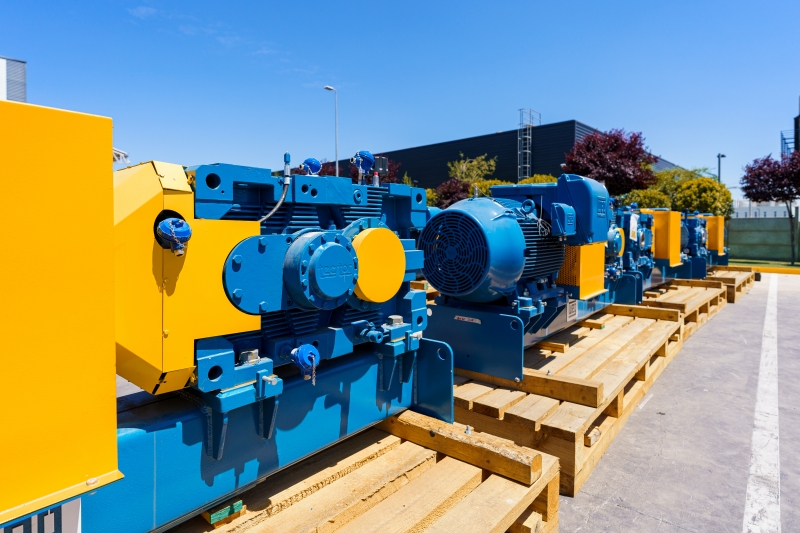 Industrial AC motors staged outdoors for DC motor replacement in a Canadian facility.