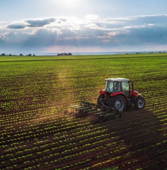 Farming plough driving across large field