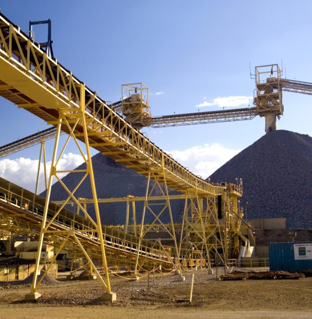 Large mining equipment in front of rock piles