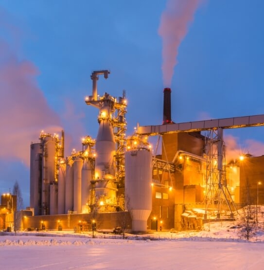 Outside view of large pulp & paper plant with smokestacks releasing gases